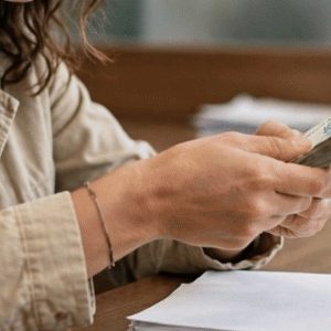 pessoa pagando por documento em cartório com notas de reais, plano médio, luz natural e contexto institucional