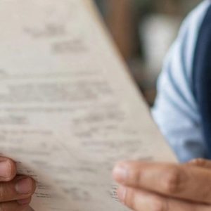 funcionário do cartório analisando escritura de imóvel genérica, sem texto legível, no ambiente do cartório